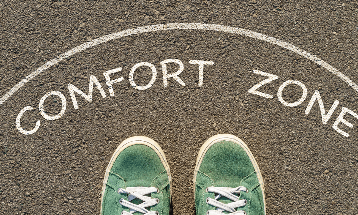 The words Comfort Zone written on a round mat with green running shoes showing