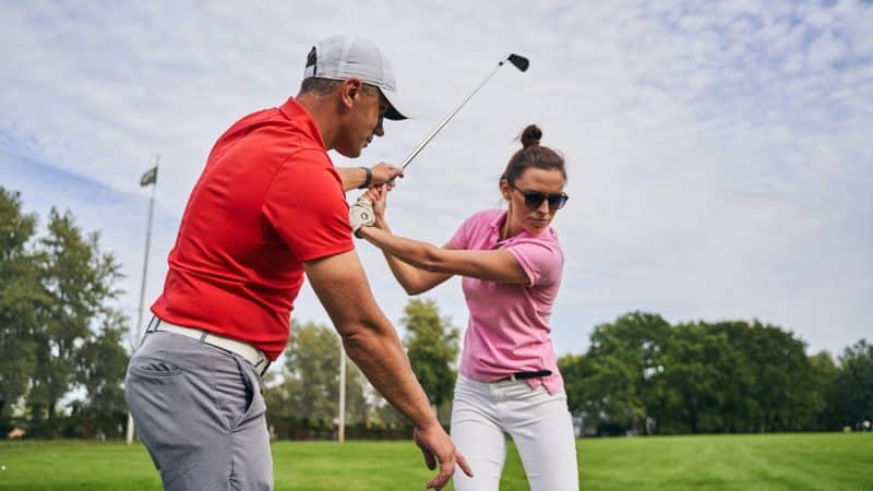 golf lessons instructor with female student