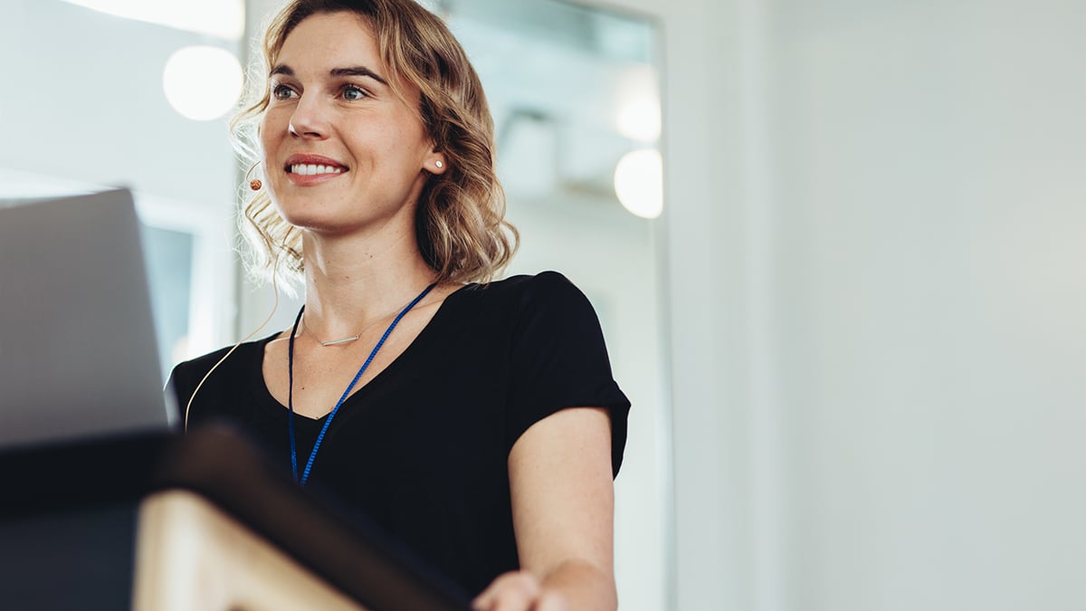 Female entrepreneur on podium in conference willing to be brave and look foolish speaking in public.